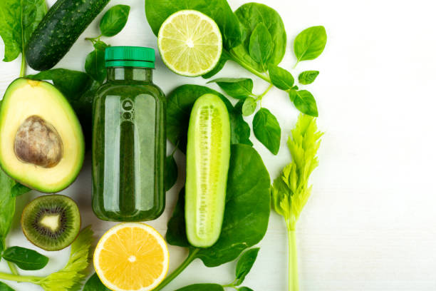 istock Avocado, spinach, cucumber, kiwi, lime, lemon, celery, spinach - green vegetables laid out around a bottle of green detox drink 1224023530