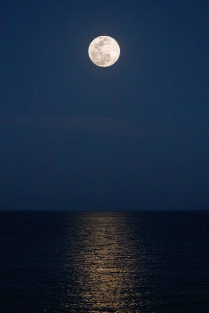 istock Bright moon illuminates the ocean 1224023734