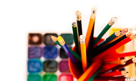 Close-up of colored pencils in a row on white background with copy space