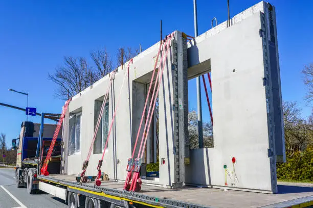 Photo of transportation of reinforced concrete precast wall panels for house construction by truck