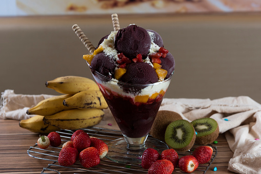 Brazilian açai on the wooden table, surrounded by fruit.