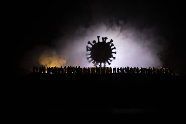 istock Coronavirus 2019-nCov novel coronavirus concept. Crowd looking on big Corona virus model at night with fog and backlight. Creative artwork decoration. Selective focus. 1224031144