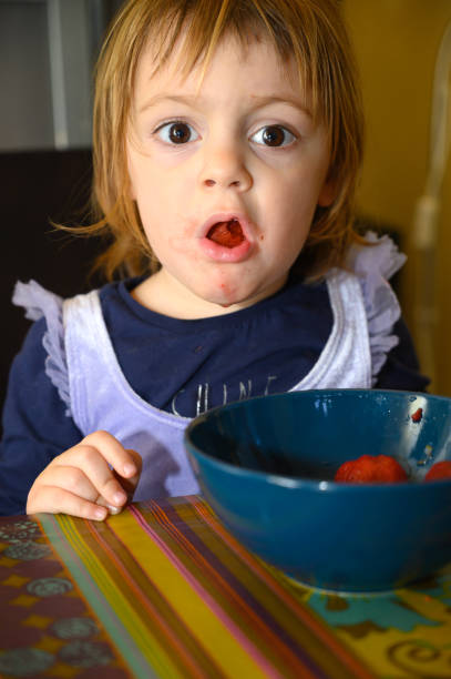 istock Girl eating strawberries 1224031595