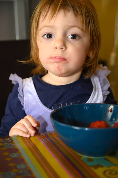 istock Girl eating strawberries 1224031776