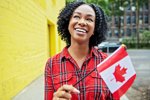 happy smiling black woman with a Canadian flag