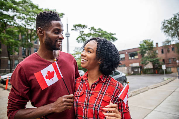 Canadian Couple Celebrating Canada Day happy young black couple, together celebrating Canada day, holding flags and smiling canada day photos stock pictures, royalty-free photos & images