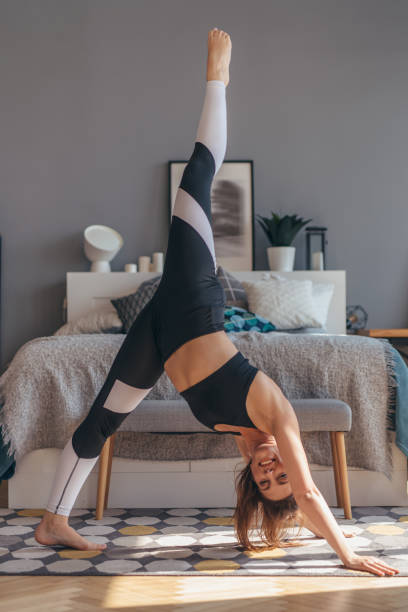 femme d’ajustement s’étirant faisant l’exercice de yoga. pose de chien à trois pattes. - body conscious photos et images de collection