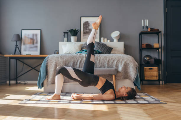 istock Fit woman trains at home and does exercise glute bridge. 1224033656