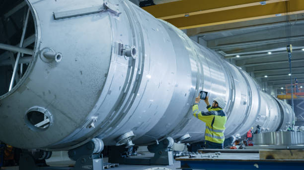 istock Heavy Industry Engineer Uses Augmented Reality Digital Tablet to Scan Large Diameter Pipe. Modern Industrial Manufacturing Technology to Design and Construct Oil, Gas and Fuels Transport Pipeline. 1224034083