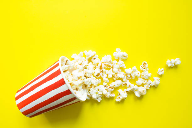 istock Paper Cup with drawn red stripes and scattered popcorn 1224034915