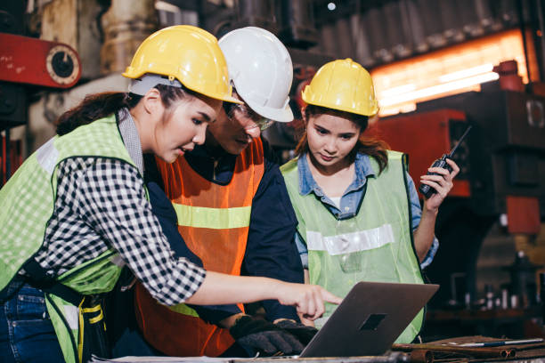 ingeniero asiático o técnico capataz capacitando a mujeres aprendices utilizando programa o sistema en la fábrica de fabricación de la industria. trabajo en equipo y personas corporativas trabajando duro en el sitio de construcción industrial - industry asian ethnicity asia manager fotografías e imágenes de stock