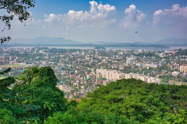 Guwahati in sunlight, in India Guwahati, India - October 22, 2016: Beautiful image of Guwahati town seen from above in Seven Sisters States of India, with Peacock island seen in the background, surrounded  by trees and hills. brahmaputra river stock pictures, royalty-free photos & images