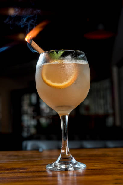 flammender cocktail auf einem holztisch - martini brand vermouth stock-fotos und bilder