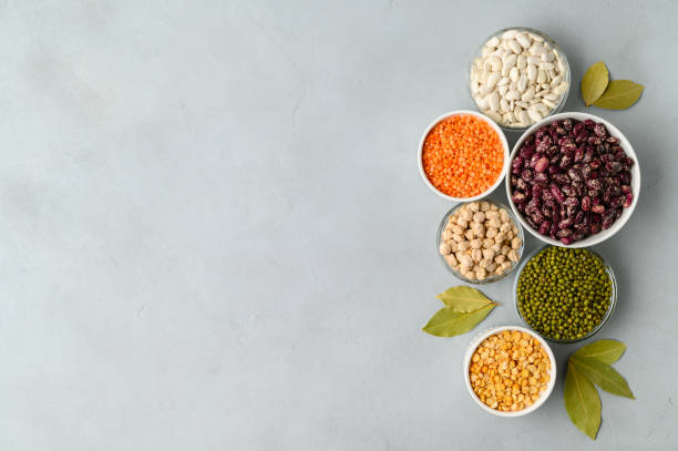 Various sources of vegetable protein: beans, lentils, peas, chickpeas, mung bean in bowls. A healthy balanced diet for vegans and vegetarians. stock photo