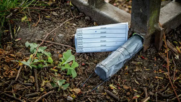 geocache container encased with duct tape and logbook hidden inside a  fence
