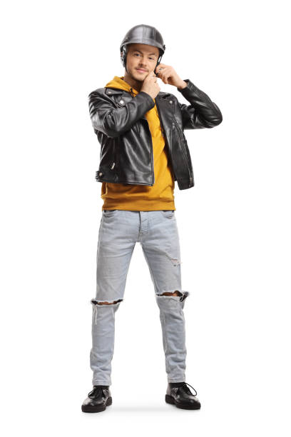 Young man in a leather jacket putting on a helmet Full length portrait of a young man in a leather jacket putting on a helmet isolated on white background motorcycle helmet stand stock pictures, royalty-free photos & images