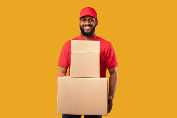 istock Courier Holding Cardboard Boxes And Parcels Standing On Yellow Background 1224042069