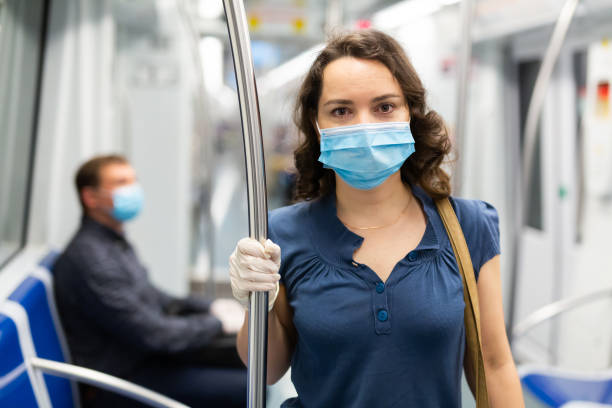 istock Woman in disposable mask in subway train 1224042479
