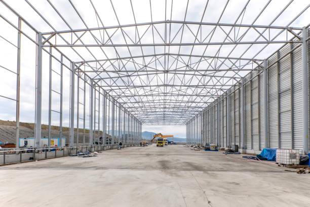 View of the structural steel beams and colums of industrial building from inside. Steels used for building construction in the US use standard alloys identified and specified by ASTM International. vista de las vigas de acero estructural y columnas de edificio industrial desde el interior. los aceros utilizados para la construcción de edificios en los ee.uu. utilizan aleaciones estándar identificadas y especificadas por astm international.