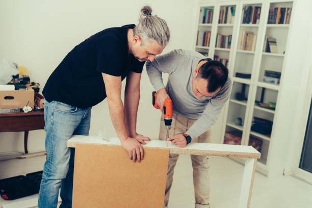 istock Two men assemble bathroom furniture 1224044676