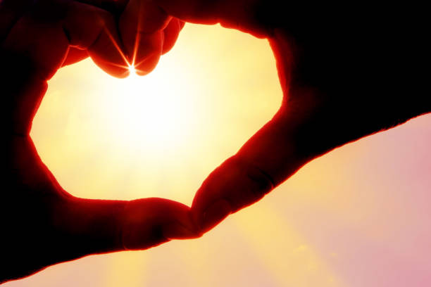 istock Hands forming a heart shape over the sun 1224045678