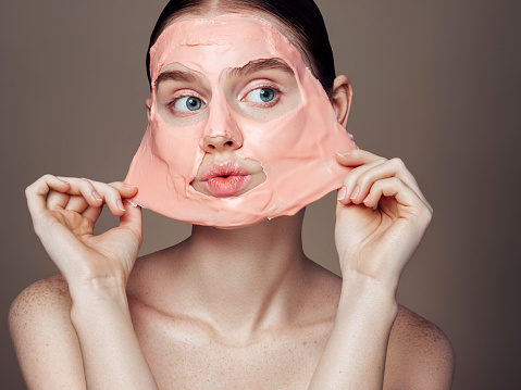 Woman removing mask from face