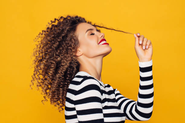 Funky young girl against yellow background Funky young girl against yellow background curly hair stock pictures, royalty-free photos & images