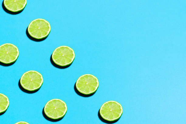 istock Minimal flat lay food texture. Summer abstract trendy fresh concept. Lime pattern on bright light blue background, copy space 1224048797