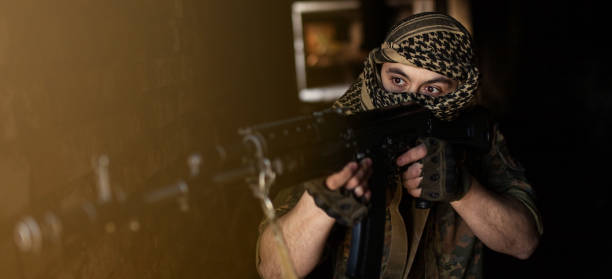 arabischer männlicher soldat in einem kopfschmuck aus dem nationalen keffiyeh mit waffen in den händen. muslim mit schusswaffen - jihad stock-fotos und bilder