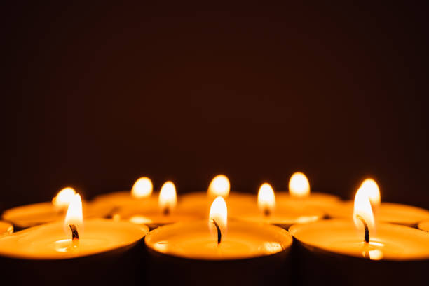 Burning candles in a row in the dark. Burning candles in a row in the dark with copy space. holocaust stock pictures, royalty-free photos & images