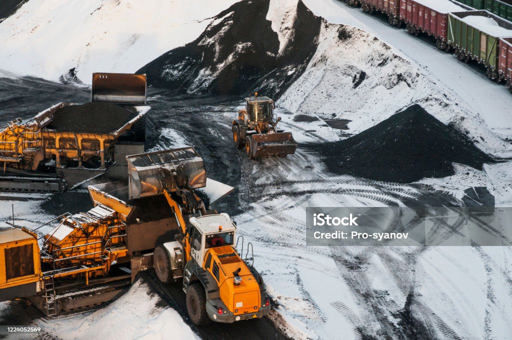 Front-end loader loads coal onto a conveyor belt Machinery Stock Photo