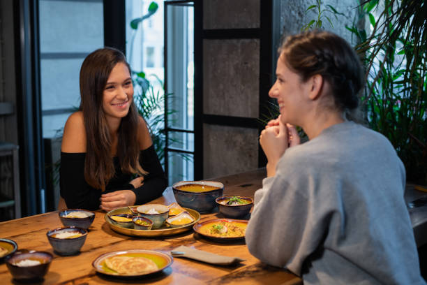 istock Two girls sitting in a cafe and talking friendly 1224053208