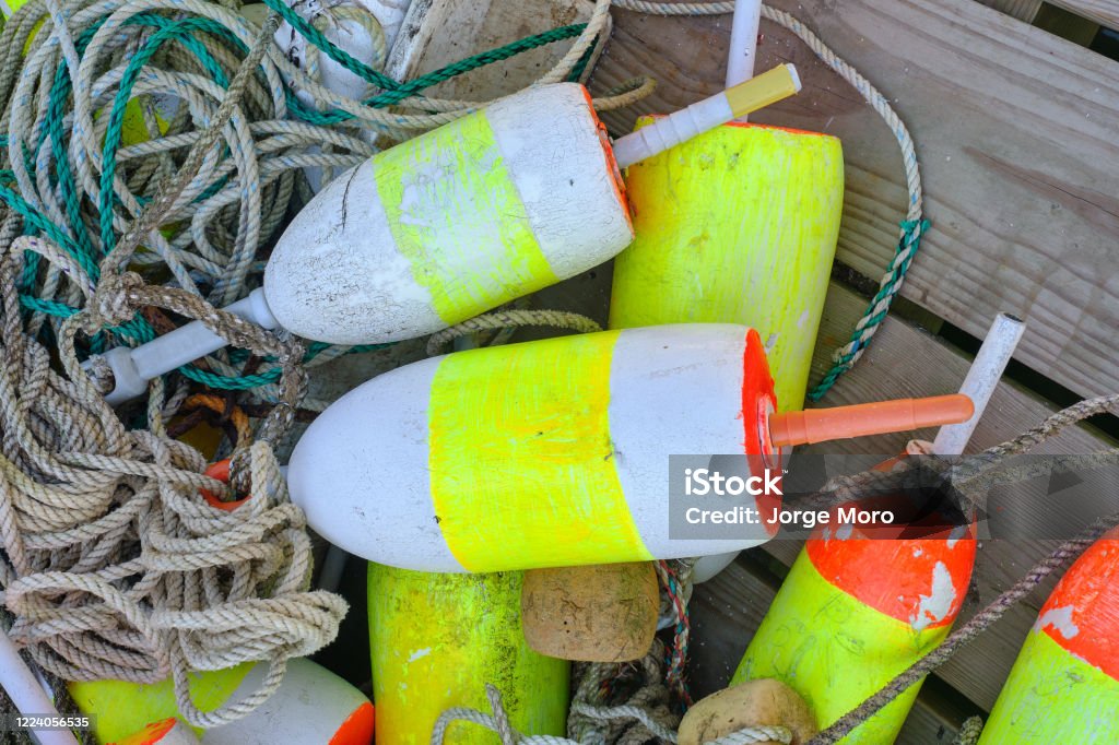 Colorful lobster floats decorate a wooden lobstrermans dock on the Maine Coast Lobsterman Stock Photo