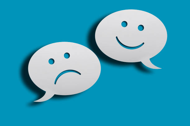 istock White chat bubbles with happy and sad face emoticon over blue background. 1224058201