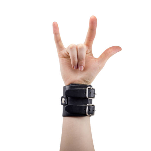 hand with leather rocker bracelet with rock and roll sign, rock music, isolated on white hand with leather rocker bracelet with rock and roll sign, rock music, isolated on white background rocker nails stock pictures, royalty-free photos & images