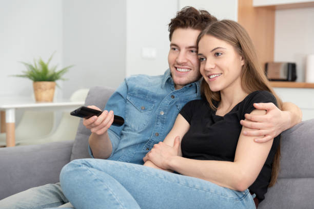 istock Young couple watching TV on sofa 1224059100