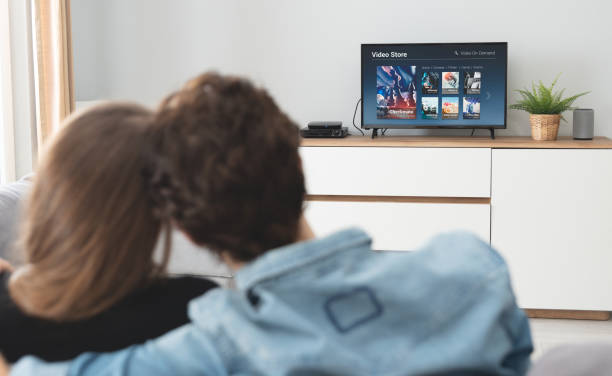 istock Young couple watching TV on sofa 1224059214