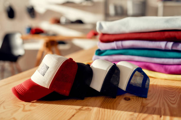 More than you expect. Custom apparel, clothes neatly folded on shelves. Stack of colorful clothing and baseball cap in the store