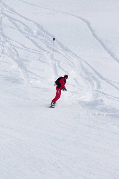 snowboarder desce em pista de esqui nevada após queda de neve no dia de inverno - snowboarding snowboard teenager red - fotografias e filmes do acervo