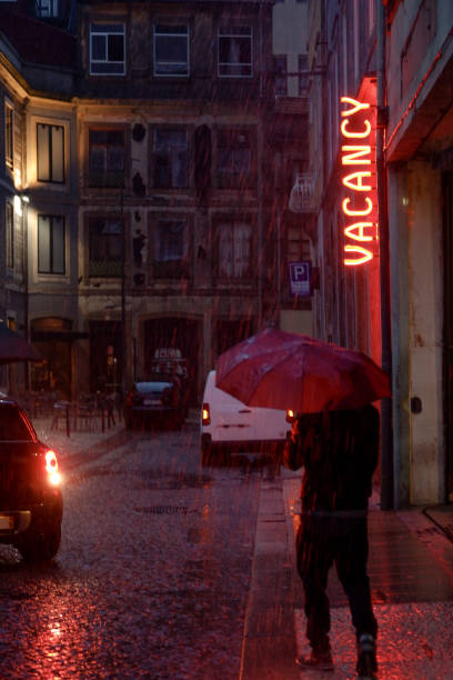 A woman with an umbrella on a city street at night in the light of red lanterns