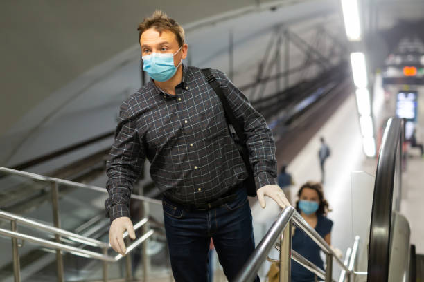 istock Man in disposable mask climbing stairs 1224074173