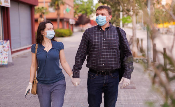 istock Couple in medical masks walking 1224074211
