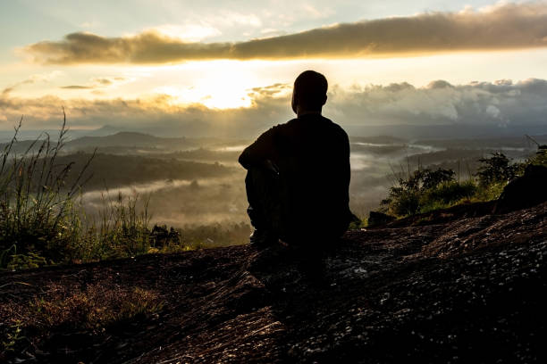 istock man backlight soaking the amazing view of mountain layers covered with white mist at dawn 1224078001