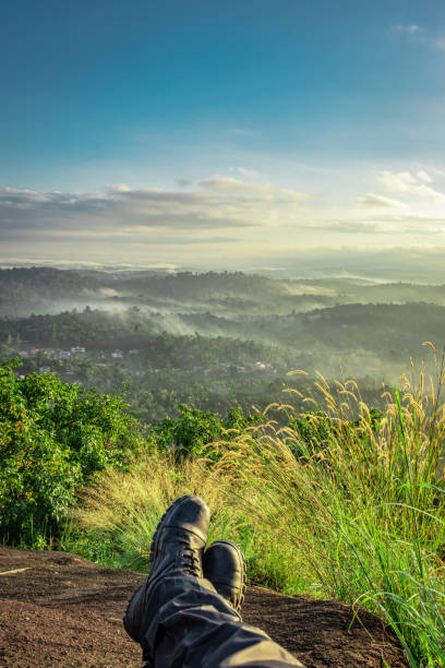 hiker resting at hilltop with breathtaking mountain layers in background