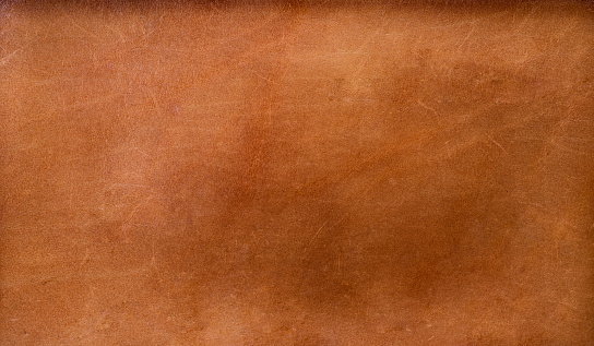 Close up brown leather wallet on wood texture.