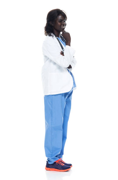 etnia africana doctora de pie frente al fondo blanco usando abrigo de laboratorio - doctor thinking asking pensive fotografías e imágenes de stock