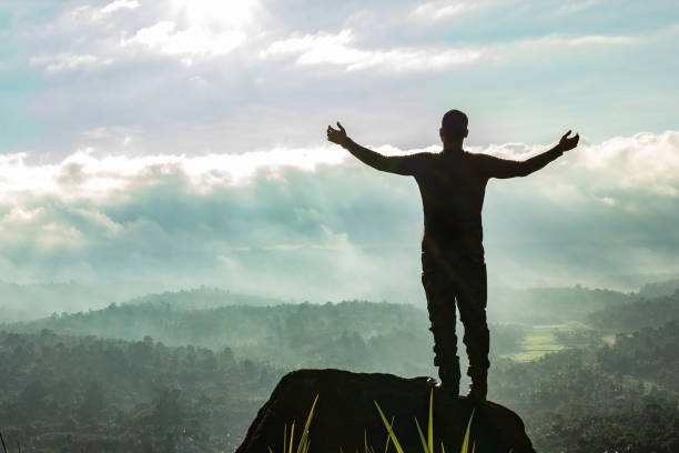 istock man backlight soaking the amazing view of mountain layers covered with white mist at dawn 1224079213