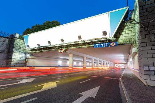 blank light box on underpass entrance, light trails and city road background, clipping path