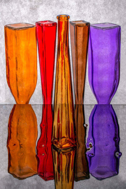 istock Still life with inverted colored bottles on a reflective surface 1224086851