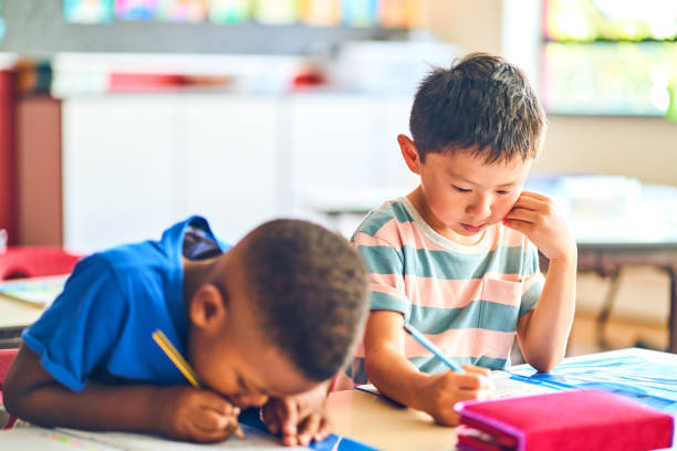 istock Multi-ethnic schoolboys writing in books at school 1224088069